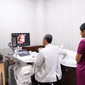 Sonographer and family watching live 3D scan on screen