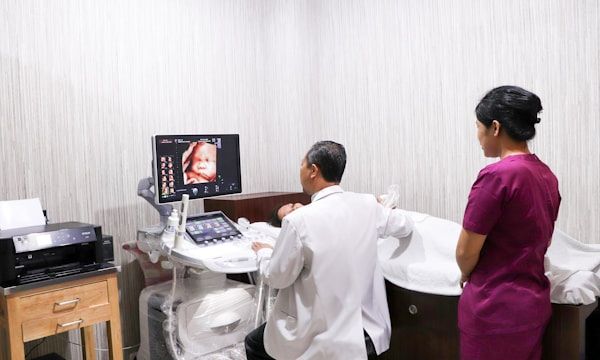 Sonographer and family watching live 4D ultrasound on screen