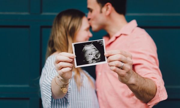 Couple celebrating their baby's gender reveal with scan