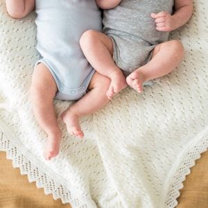 Two newborn twins resting side by side