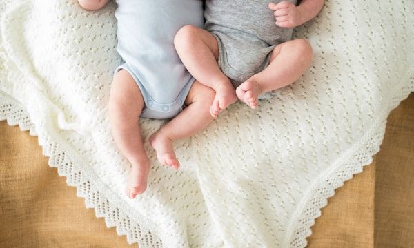 Two newborn twins resting side by side